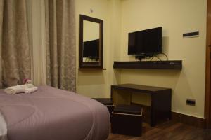 a bedroom with a bed and a desk with a television at Denzong Khim in Gangtok +19 photos