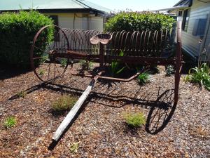 un viejo banco oxidado sentado en un patio en Redgate Country Cottages, en Moffatdale