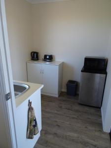 a small kitchen with a sink and a stove at Redgate Country Cottages in Moffatdale