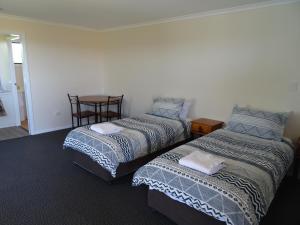 two beds sitting next to each other in a room at Redgate Country Cottages in Moffatdale