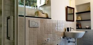 ein Bad mit einem Waschbecken, einem Spiegel und einer Dusche in der Unterkunft Appartamento nel borgo con splendida vista sul mare in Cervo
