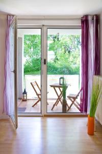Une porte ouverte s'ouvre sur une terrasse avec une table. dans l'établissement Ferienwohnung Rodenhof, à Sarrebruck