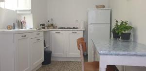 a kitchen with a white refrigerator and a table at Appartamento nel borgo con splendida vista sul mare in Cervo +13 photos