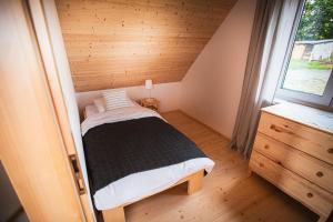 a small bedroom with a bed and a window at Wilk i Owca in Istebna