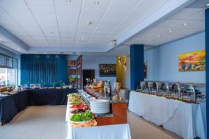 a buffet line with plates of food in a restaurant at Hotel des Mille Collines in Kigali