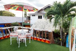 a patio with a table and chairs and an umbrella at Lala Panzi Bed and Breakfast in Puerto Princesa City