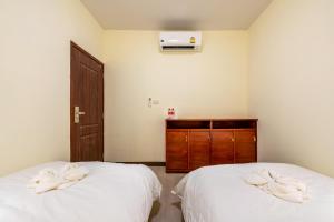 two beds in a room with towels on them at Scala Hostel in Bangkok