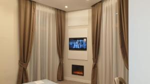 una camera con tende e TV a parete di Dante Relais a Napoli