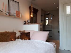 - une chambre avec un lit blanc et des oreillers dans l'établissement Het Gindrahuis, à Bladel