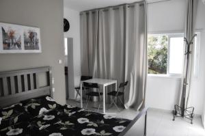 1 dormitorio con 1 cama y 1 mesa con sillas en Apartment Happiness, en Bat Yam