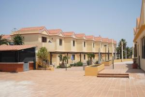 un gran edificio con un patio con palmeras en Luz Azul, en Costa Calma