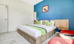 Un dormitorio con una cama y una pared azul. en Treebo Mall View, DLF Phase II, en Gurgaon