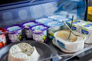 a refrigerator filled with yogurt and a plate of food at Volcanic Charming House in Ribeira Grande
