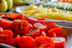 a plate of tomatoes and french fries on a table at Volcanic Charming House in Ribeira Grande