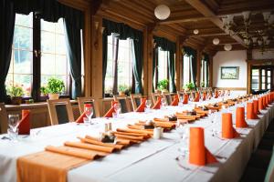 a row of tables in a room with windows at Hotel Tisa Pohorje in Pohorje