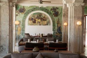 RAAS Devigarh في أودايبور: غرفة طعام مع لوحة على الحائط
