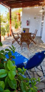 een patio met 2 stoelen en een tafel en een blauw zwembad bij Studios Marfo in Batsi
