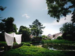 a garden with a tent and a pond at Relais & Châteaux Taubenkobel in Schützen am Gebirge