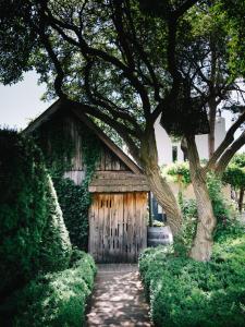 a building with a wooden door and a tree at Relais & Ch&acirc;teaux Taubenkobel in Sch&uuml;tzen am Gebirge