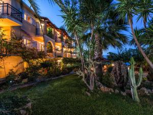 an exterior view of a hotel at night with palm trees at Calypso Studios in Amoudi