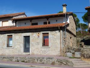 una vieja casa de piedra al lado de una calle en Casas del parador - Abadía, en Sequeros