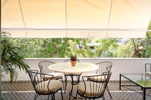 d'une terrasse avec une table et des chaises devant une fenêtre. dans l'établissement The Fancy Philosopher Apartment, à Athènes