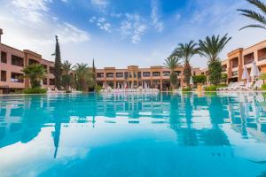 basen w ośrodku z palmami i budynkami w obiekcie Zalagh Kasbah Hotel & Spa w Marakeszu