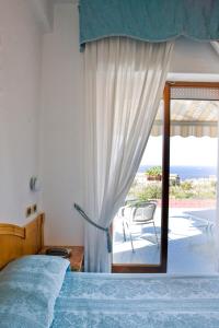 a bedroom with a bed and a view of the ocean at Hotel La Primavera in Massa Lubrense