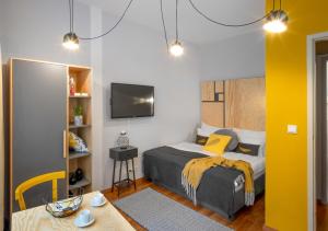 1 dormitorio con cama, mesa y TV en City Leaf Apartments by Adrez en Praga