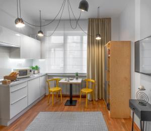 Una cocina con una mesa y sillas amarillas. en City Leaf Apartments, en Praga 17 fotos más