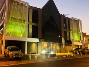 a building with cars parked in front of it at Jockey Class Hotel in Teresina