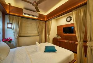 una camera con letto bianco e TV di Tranquil La Casa a Pune
