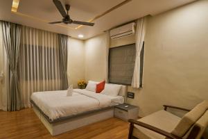 1 dormitorio con 1 cama y ventilador de techo en Tranquil La Casa, en Pune