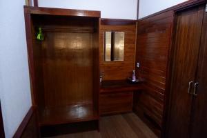 a bathroom with a wooden door and a sink at Khao Sok Nature Resort in Khao Sok National Park