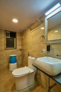 uma casa de banho com um WC branco e um lavatório. em Tranquil La Casa em Pune