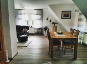 uma sala de estar com uma mesa de madeira e cadeiras em Traumnest em Großheide