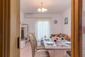 ein Esszimmer und ein Wohnzimmer mit einem Tisch und Stühlen in der Unterkunft Holiday House Kristina in Radovani