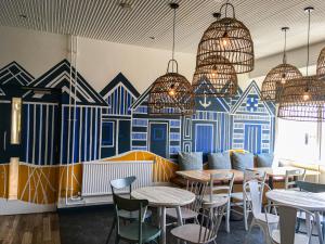 a restaurant with tables and chairs and a mural at YHA Broad Haven in Broad Haven