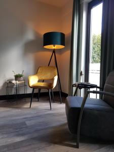 een woonkamer met een stoel en een lamp bij B&B La Vita Verde in Susteren