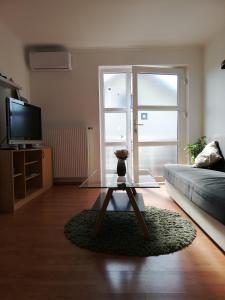uma sala de estar com uma mesa de vidro e um sofá em Guest house Ruža em Tenja