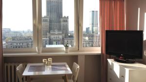 Pokój ze stołem, telewizorem i oknem w obiekcie Bagno 7 City centre w Warszawie