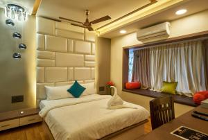 1 dormitorio con cama, escritorio y ventana en Tranquil La Casa, en Pune