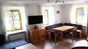 sala de estar con mesa y TV en Ferienhaus Buxbaum, en Arbesbach