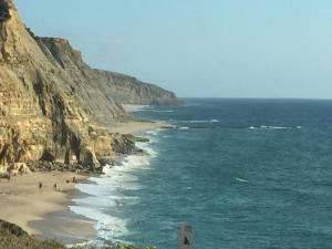 una spiaggia con persone sulla sabbia e sull'oceano di Magoito1 a Sintra