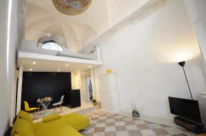 a living room with a yellow couch and a table at HOLLIDAY CHARMING HOME in Trento