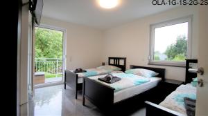 two beds in a room with two windows at Overath Luxus Apartments nähe Köln City/Messe in Overath