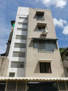 a tall white building with windows at Tranquil La Casa in Pune