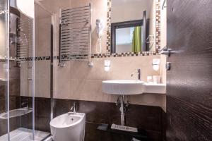 ein Badezimmer mit einem Waschbecken, einem WC und einem Spiegel in der Unterkunft Rome Kings Suite in Rom