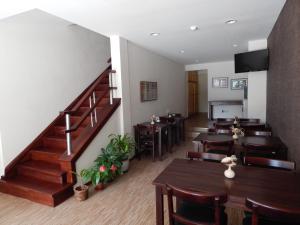 Un restaurante con mesas y sillas y una escalera. en Hotel Timbó, en Piriápolis