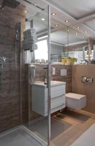La salle de bains est pourvue d'une douche, d'un lavabo et de toilettes. dans l'établissement Appart-Hotel REB_ART, à Deidesheim